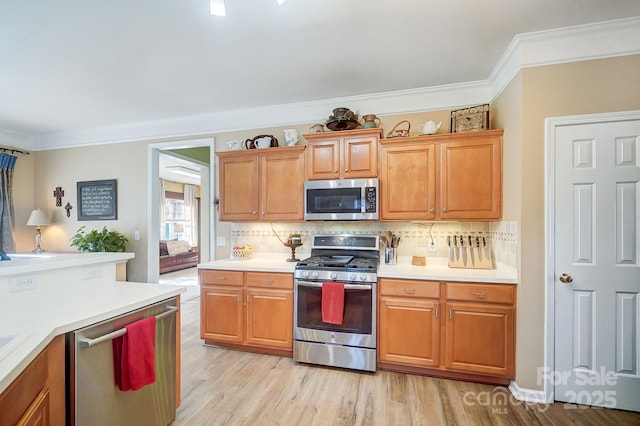 kitchen featuring backsplash, light hardwood / wood-style flooring, ornamental molding, and appliances with stainless steel finishes