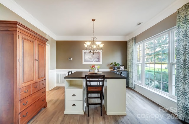 dining room featuring a healthy amount of sunlight, light hardwood / wood-style floors, and an inviting chandelier