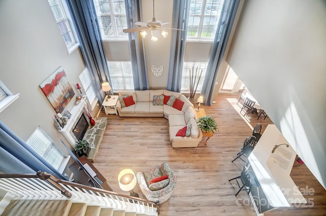 living room featuring a high ceiling, plenty of natural light, and ceiling fan