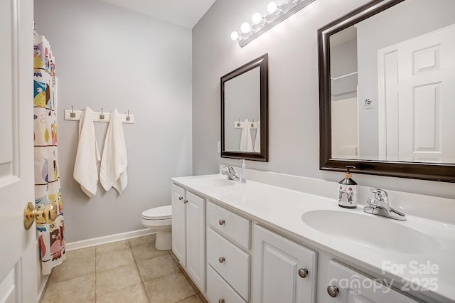 bathroom with tile patterned flooring, vanity, and toilet