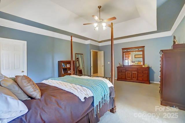 bedroom featuring light colored carpet, a raised ceiling, and ceiling fan