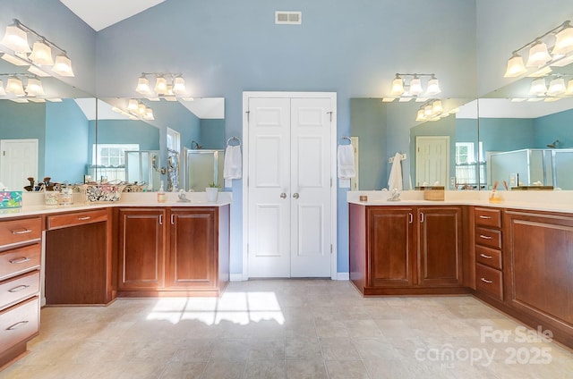 bathroom featuring tile patterned flooring, lofted ceiling, a shower with shower door, and vanity