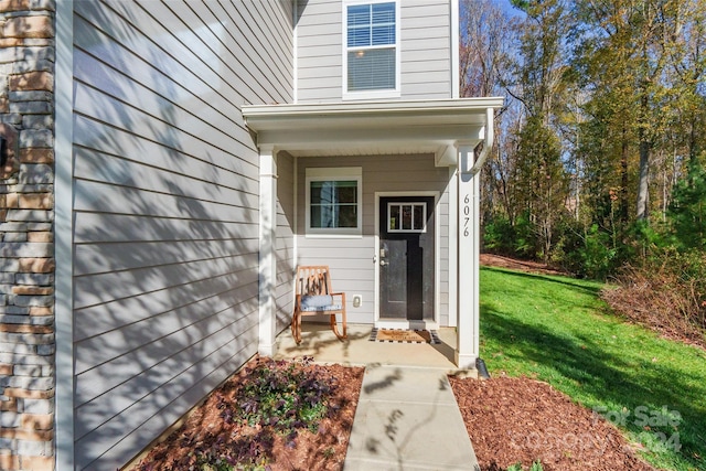 entrance to property featuring a lawn