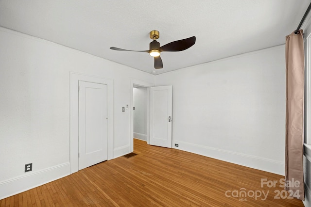 unfurnished bedroom with wood-type flooring, ceiling fan, and ornamental molding