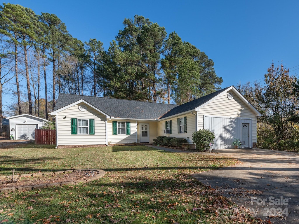 single story home with a garage and a front lawn