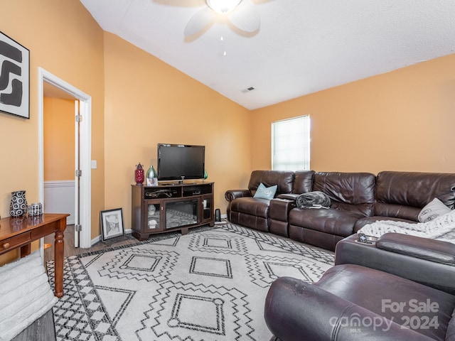 living room featuring ceiling fan, carpet floors, and vaulted ceiling