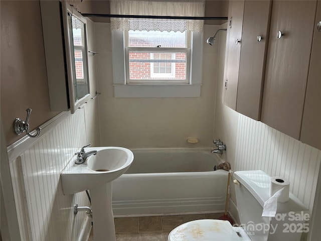 bathroom featuring toilet, tile patterned floors, and shower / washtub combination