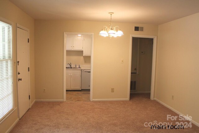 unfurnished dining area featuring a chandelier, sink, and light colored carpet