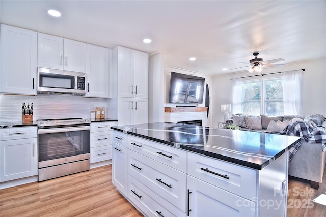 kitchen featuring white cabinets, stainless steel appliances, and light hardwood / wood-style floors