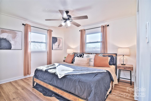 bedroom with light hardwood / wood-style floors, ceiling fan, and crown molding