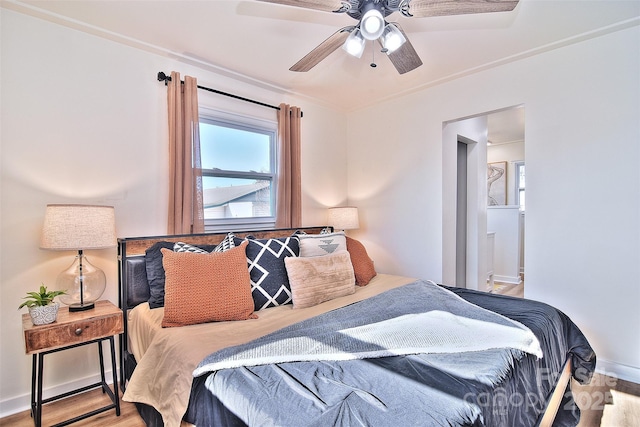 bedroom with ensuite bath, ceiling fan, and hardwood / wood-style flooring