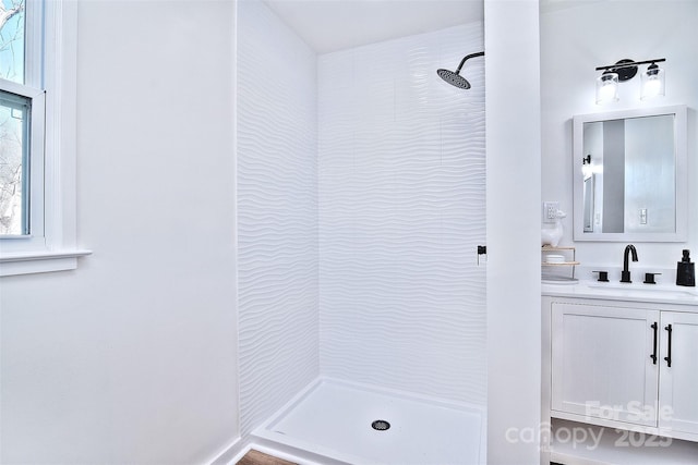 bathroom featuring a tile shower and vanity