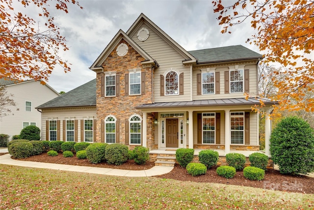 view of front of house featuring covered porch and a front yard