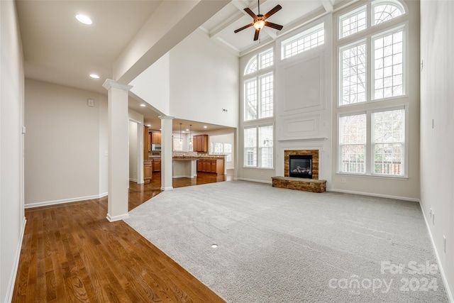 unfurnished living room with dark hardwood / wood-style flooring, a towering ceiling, and a wealth of natural light