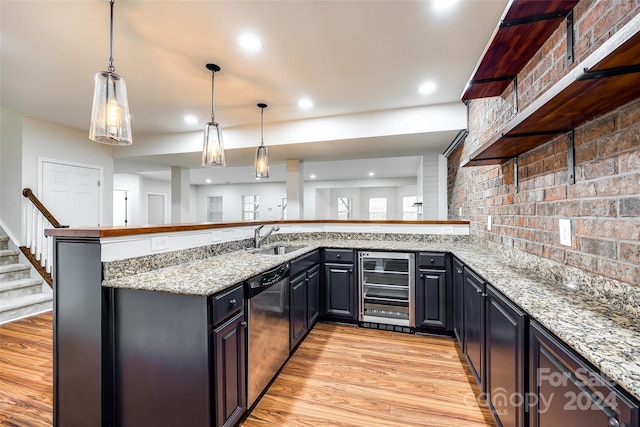 kitchen featuring light stone countertops, light wood-type flooring, beverage cooler, pendant lighting, and dishwasher