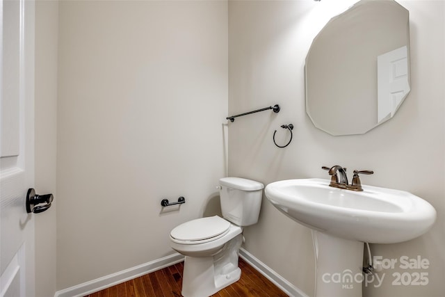 bathroom with hardwood / wood-style floors and toilet