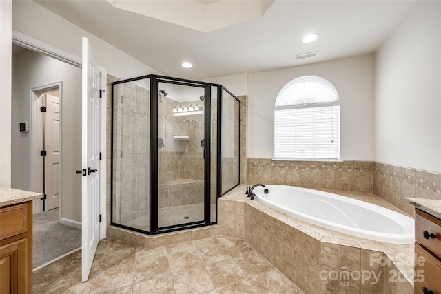 bathroom featuring vanity and independent shower and bath