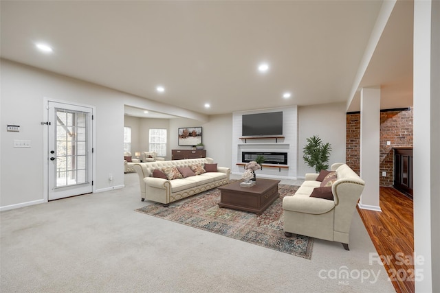 living room with a large fireplace and light colored carpet