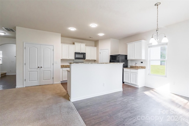 kitchen featuring black appliances, a center island, and white cabinets