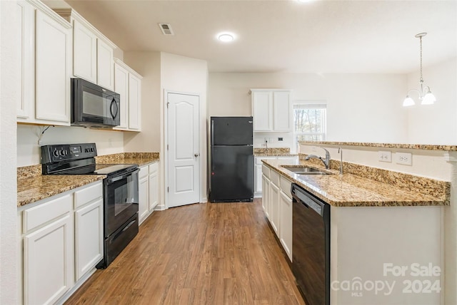 kitchen featuring an inviting chandelier, black appliances, light hardwood / wood-style flooring, decorative light fixtures, and white cabinetry