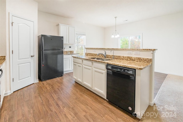 kitchen with a wealth of natural light, white cabinetry, sink, and black appliances