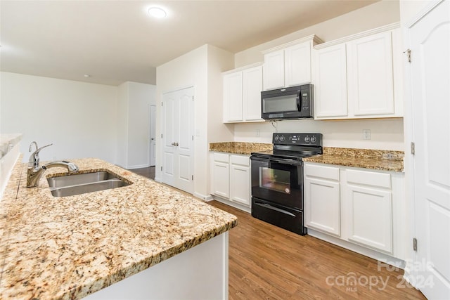 kitchen featuring light stone countertops, white cabinetry, sink, light hardwood / wood-style flooring, and black appliances