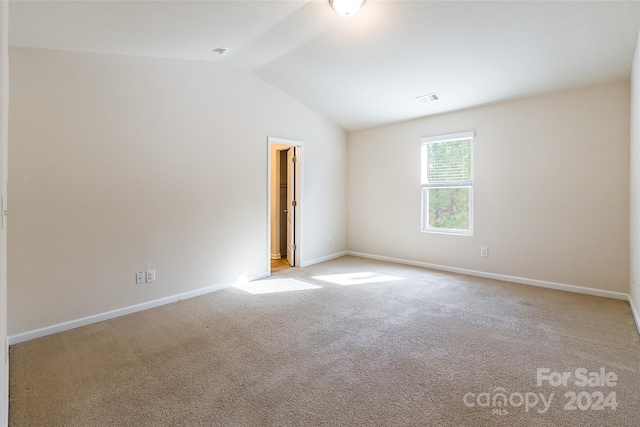 empty room featuring light carpet and lofted ceiling