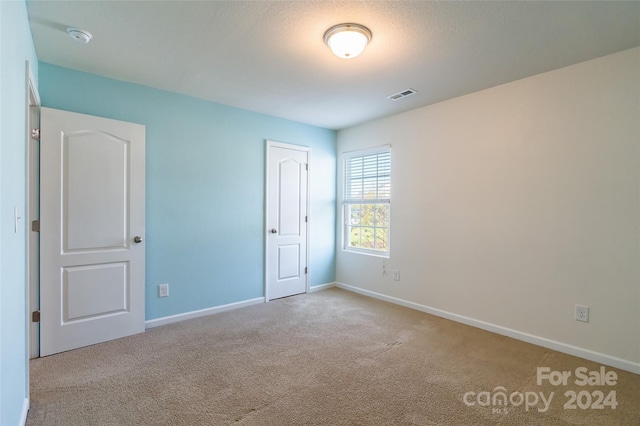 carpeted spare room with a textured ceiling