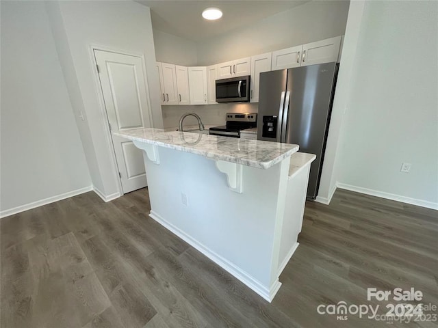 kitchen featuring white cabinets, stainless steel appliances, light stone countertops, and dark hardwood / wood-style floors