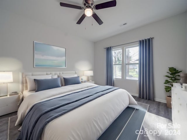 bedroom with dark hardwood / wood-style flooring and ceiling fan