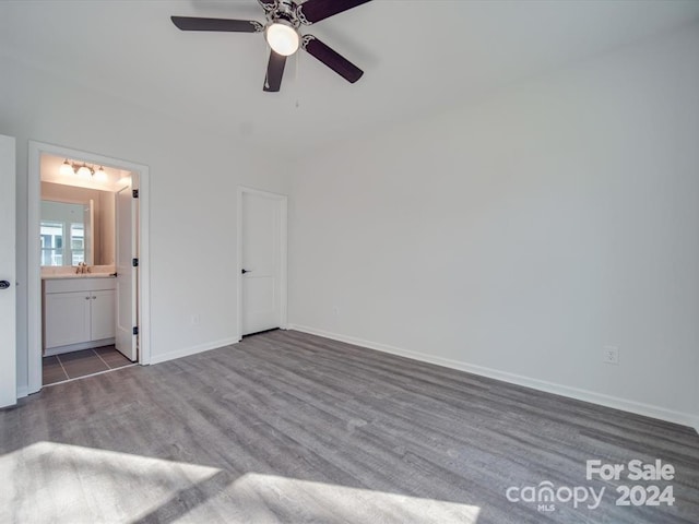 unfurnished bedroom featuring hardwood / wood-style flooring, ensuite bathroom, ceiling fan, and sink