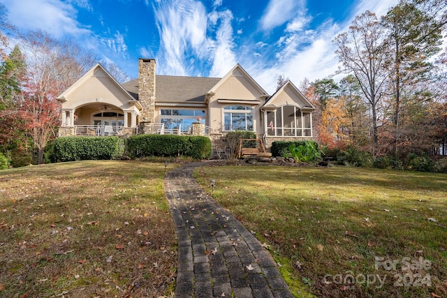 view of front of property with a sunroom and a front yard