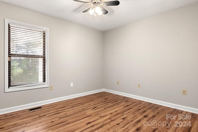 unfurnished room featuring wood-type flooring, a textured ceiling, and ceiling fan