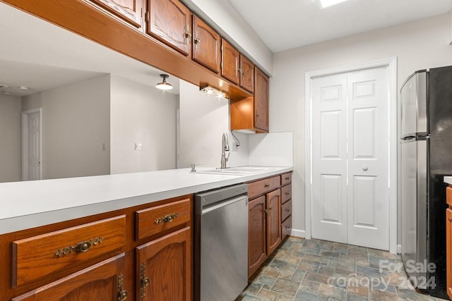 924 Cranberry Cir Unit 50-C, Fort Mill, SC 29715 - kitchen featuring appliances with stainless steel finishes, a sink, brown cabinets, stone finish floors, and light countertops