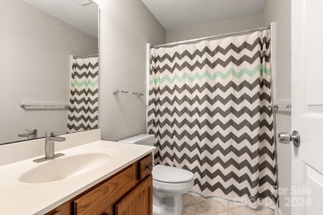 bathroom with a shower with curtain, vanity, a textured ceiling, tile patterned flooring, and toilet