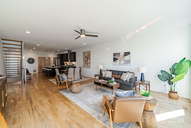 living room featuring ceiling fan and light wood-type flooring