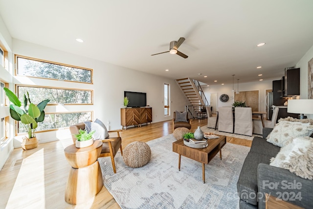 living room featuring ceiling fan and light hardwood / wood-style flooring