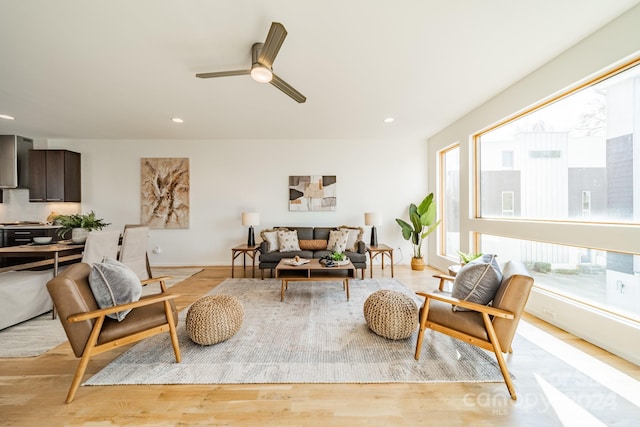 living room with light wood-type flooring and ceiling fan