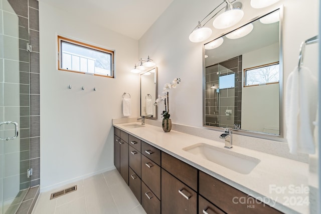 bathroom with tile patterned floors, a shower with door, and vanity