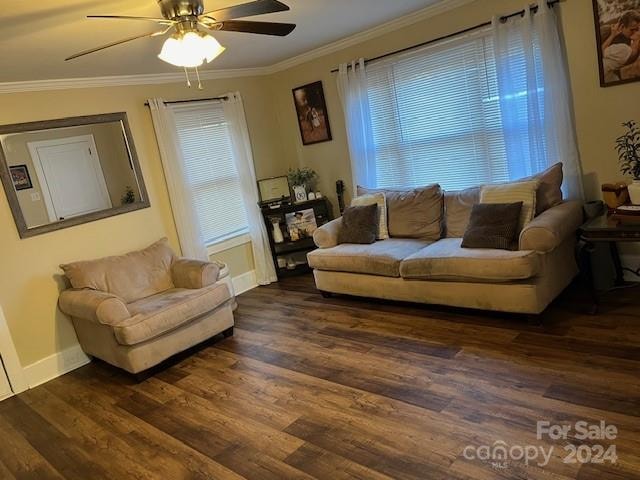 living room featuring a wealth of natural light, dark hardwood / wood-style floors, ceiling fan, and ornamental molding