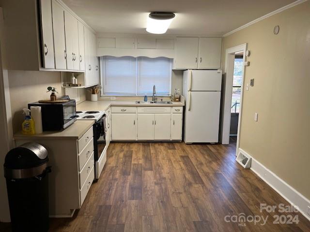 kitchen with dark hardwood / wood-style floors, white cabinetry, white appliances, and sink