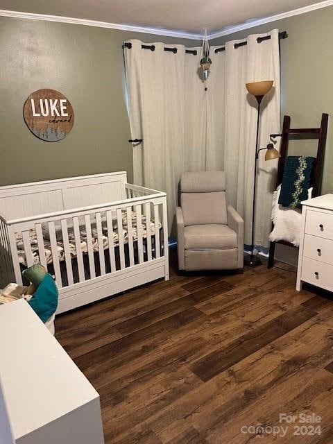 bedroom featuring a crib, dark hardwood / wood-style floors, and ornamental molding