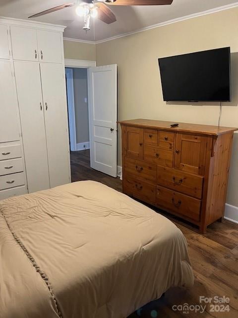 bedroom featuring ornamental molding, a closet, ceiling fan, and dark wood-type flooring