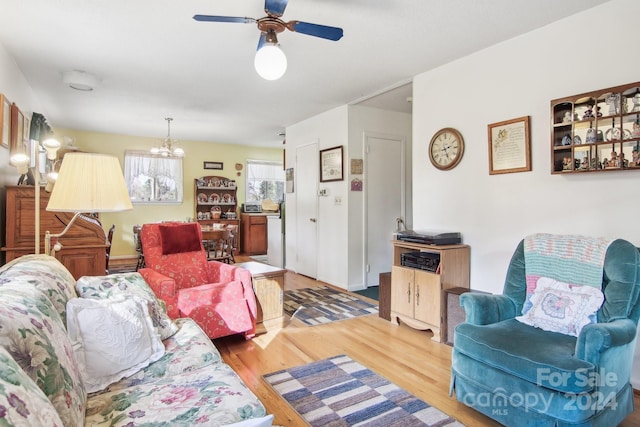 living room with hardwood / wood-style flooring and ceiling fan with notable chandelier