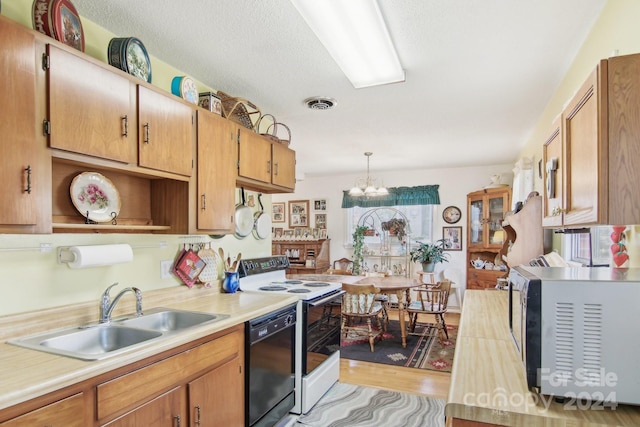 kitchen with dishwasher, an inviting chandelier, sink, hanging light fixtures, and light wood-type flooring