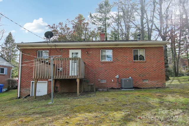 rear view of house featuring central AC and a yard