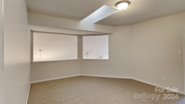 spare room featuring carpet flooring and a textured ceiling