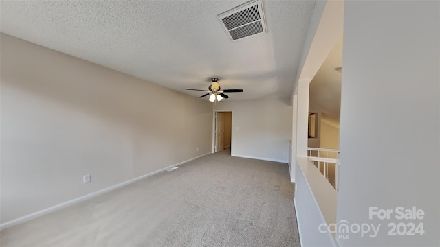 carpeted empty room with a textured ceiling and ceiling fan