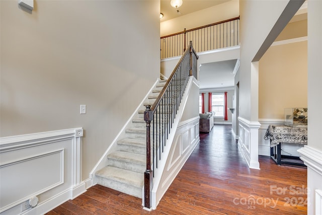 stairs featuring hardwood / wood-style floors and crown molding