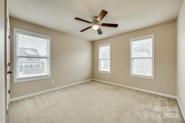 unfurnished room with ceiling fan, plenty of natural light, and light colored carpet